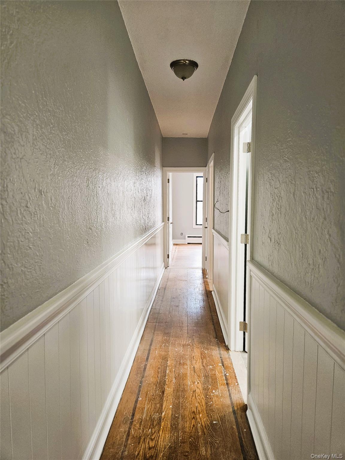 30-32 84th Street Queens, NY 11370 - Photo 14 of 37 a view of a hallway with wooden floor and staircase
