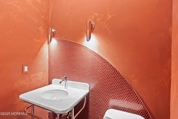 a bathroom with a sink a toilet and a mirror