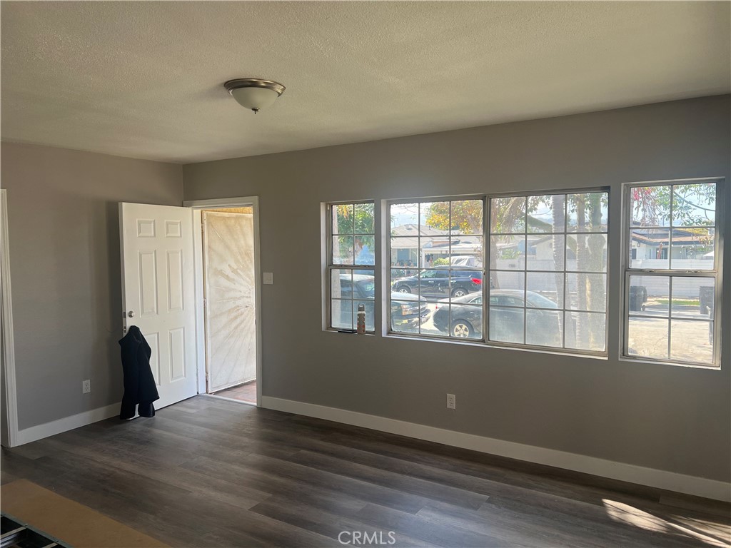 1116 McDonald Avenue Wilmington, CA 90744 - Photo 2 of 3 an empty room with wooden floor and windows