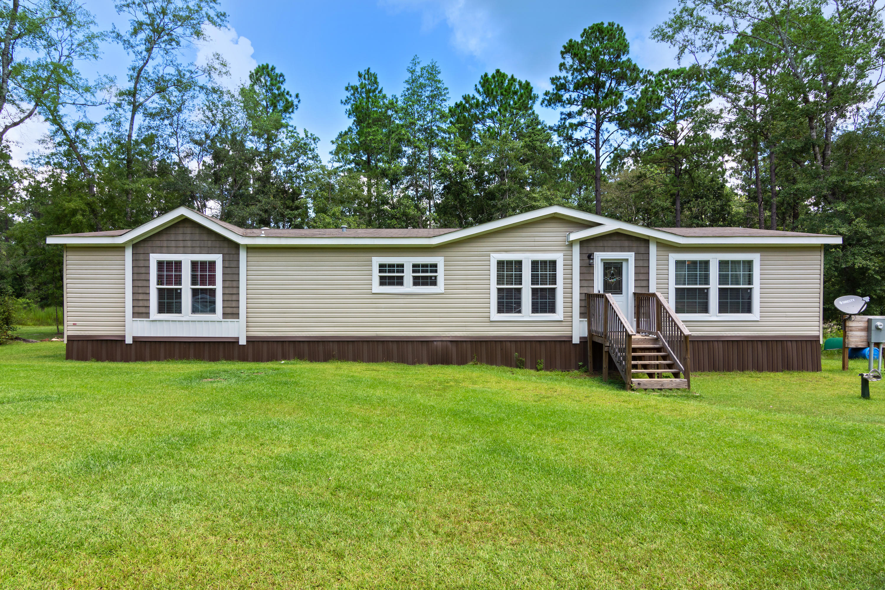 2185 Curtis Madden Road Baker, FL 32531 - Photo 1 of 41 a front view of a house with a garden