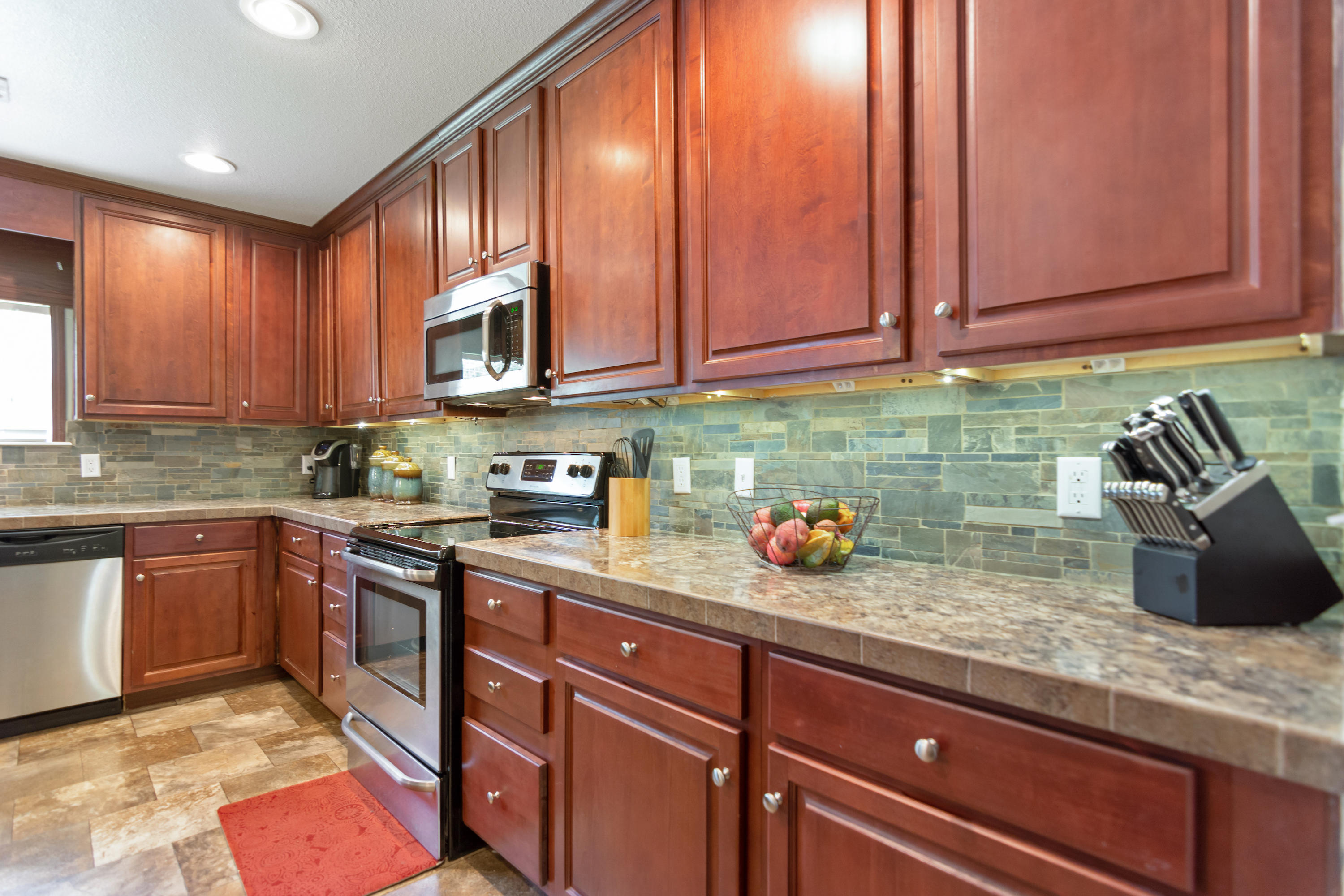 2185 Curtis Madden Road Baker, FL 32531 - Photo 10 of 41 a kitchen with stainless steel appliances granite countertop a sink stove and cabinets