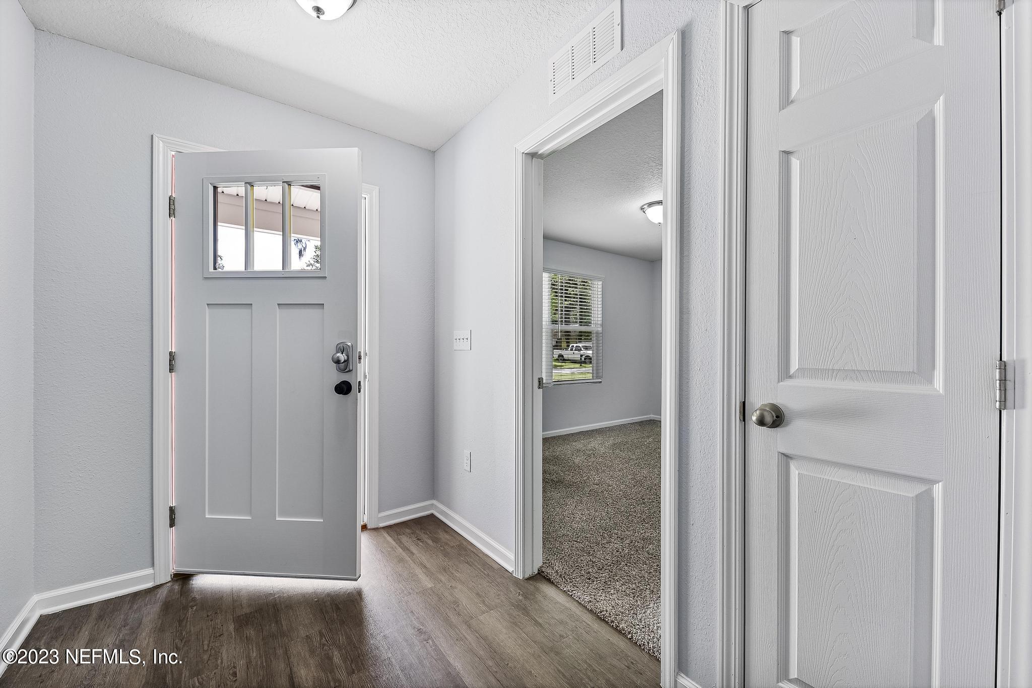 4118 Spring Park Circle Jacksonville, FL 32207 - Photo 4 of 21 an empty room with windows and wooden floor