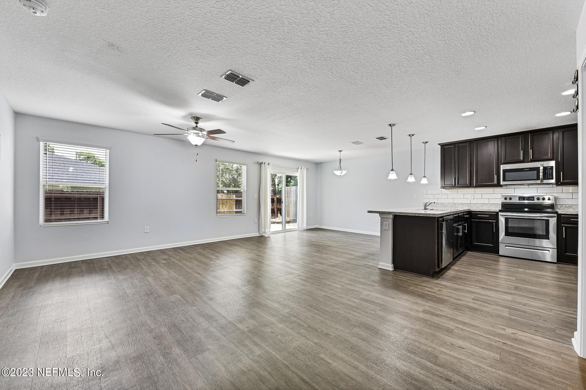 4118 Spring Park Circle Jacksonville, FL 32207 - Photo 5 of 21 a view of kitchen with stainless steel appliances granite countertop a stove top oven a sink dishwasher a microwave oven and a dining table with wooden floor