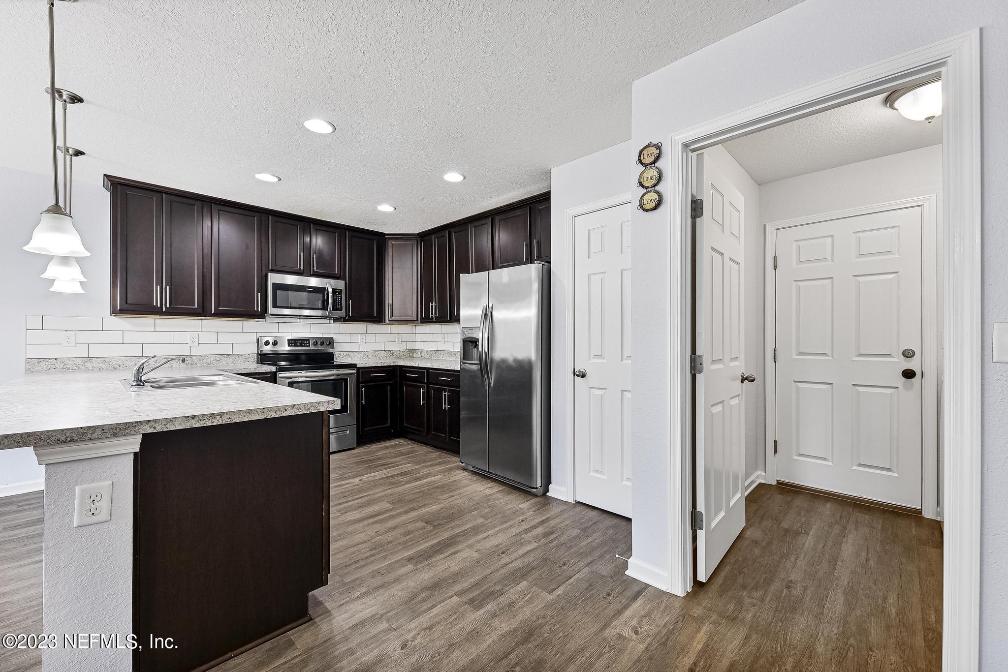 4118 Spring Park Circle Jacksonville, FL 32207 - Photo 8 of 21 a kitchen with kitchen island granite countertop wooden floors stainless steel appliances a sink and cabinets