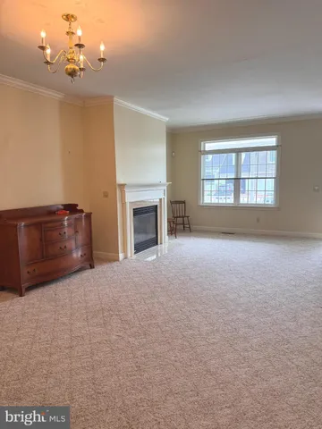 a view of an empty room with a fireplace and a window