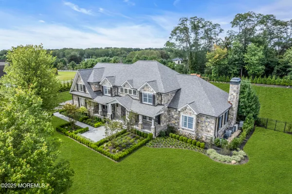 a aerial view of a house with a big yard and large trees