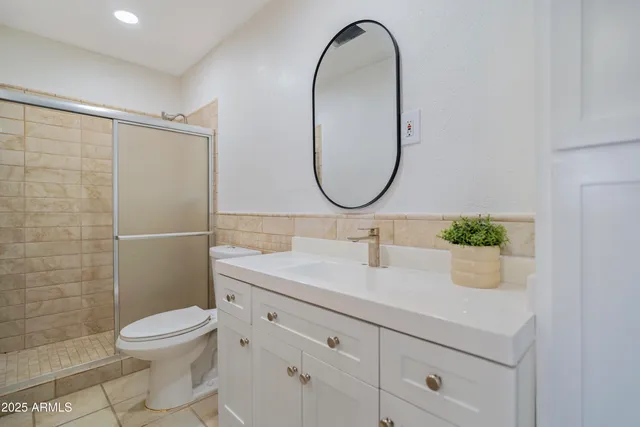 a bathroom with a sink a toilet and a mirror