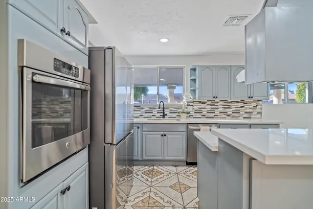 a kitchen with stainless steel appliances granite countertop a sink and cabinets