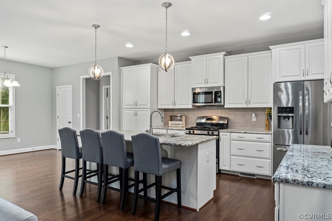 1330 Miners Trail Road Midlothian, VA 23114 - Photo 10 of 49 a kitchen with stainless steel appliances granite countertop a stove top oven a refrigerator a sink and a dining table with chairs