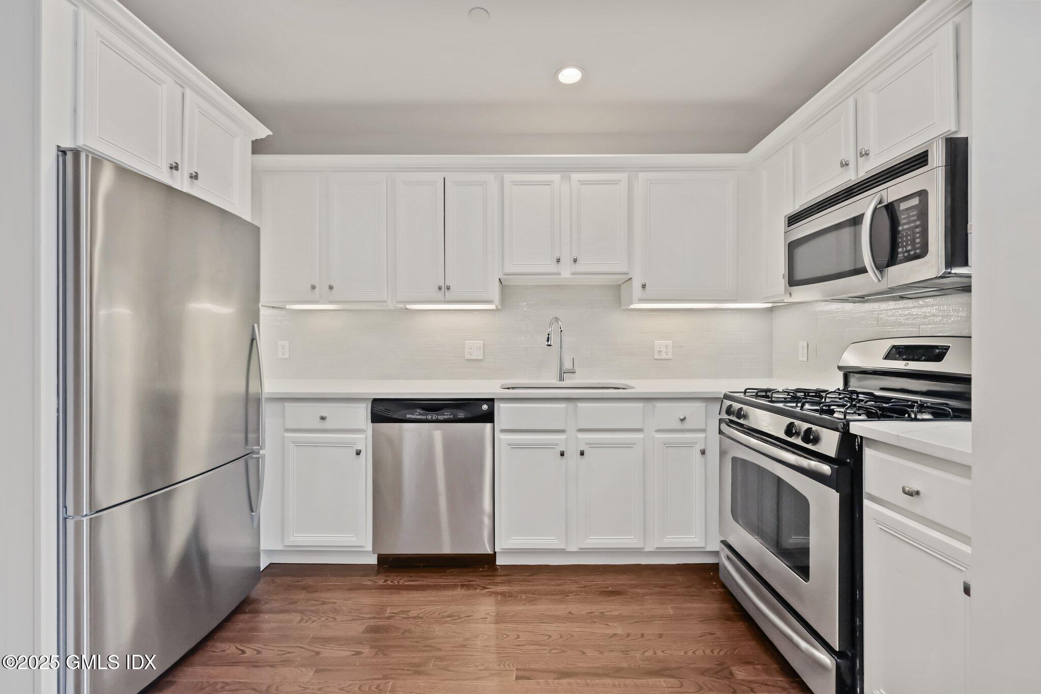 2 East Elm Street, Unit 42 Greenwich, CT 06830 - Photo 6 of 24 a kitchen with stainless steel appliances granite countertop a refrigerator stove and white cabinets