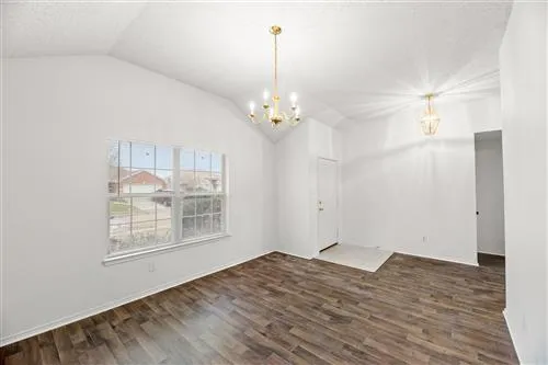 a view of a room with wooden floor and white walls