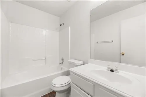 a bathroom with a sink a toilet and a large mirror