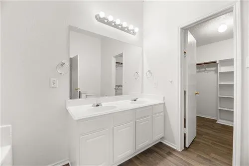 a spacious bathroom with a double vanity sink mirror and shower