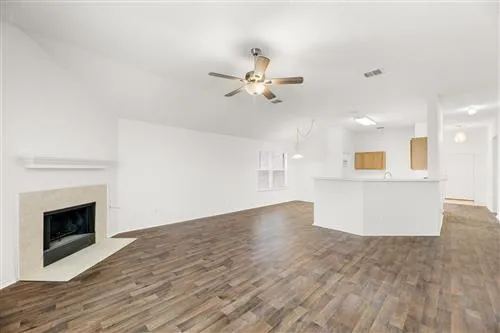a view of a kitchen with wooden floor and a fireplace