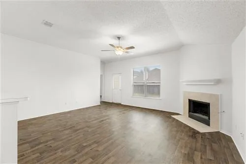 a view of an empty room with a fireplace and a window