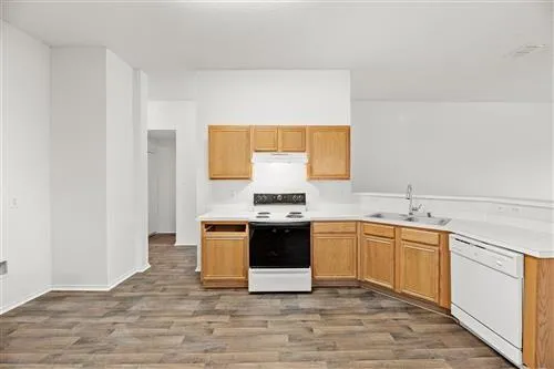 a large white kitchen with stainless steel appliances granite countertop a stove and a sink