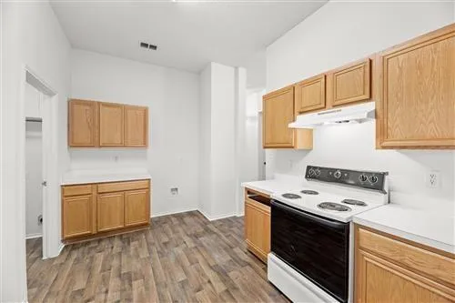 a kitchen with granite countertop cabinets stainless steel appliances and wooden floor