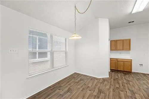 a view of a room with wooden floor and windows