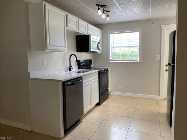 a kitchen with a sink appliances and cabinets