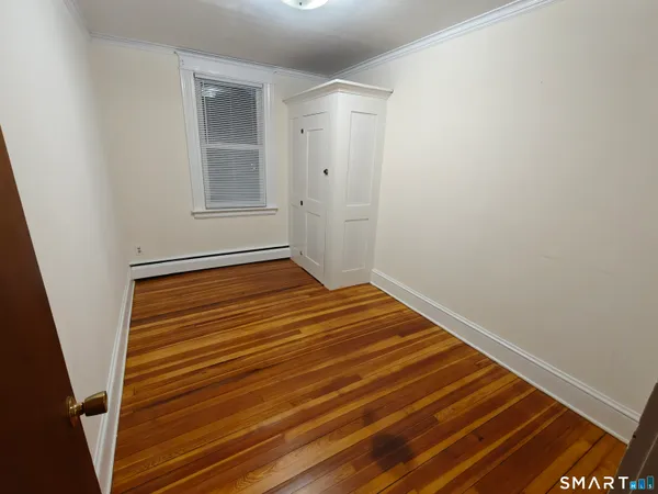 a view of a room with wooden floor and white walls