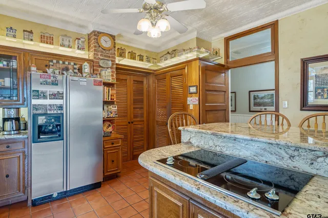 a kitchen with stainless steel appliances granite countertop a refrigerator a stove and a sink with couches