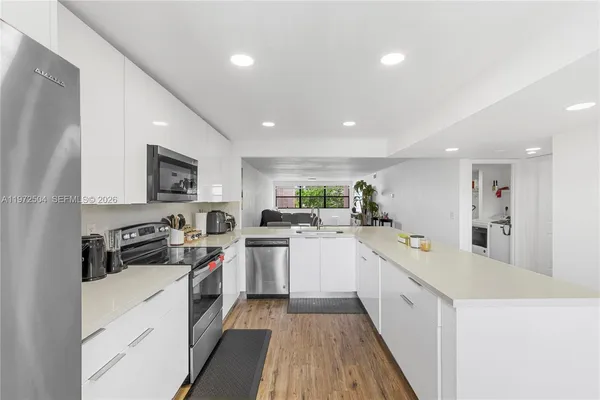 a kitchen with white cabinets and appliances