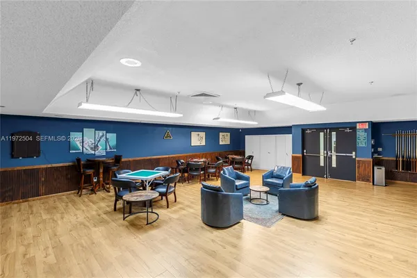 a living room with furniture a flat screen tv and kitchen view