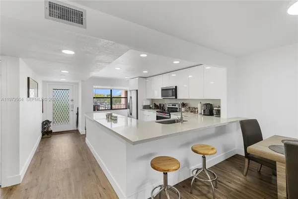 a large kitchen with a table and chairs