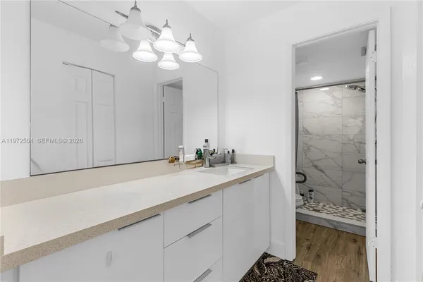 a bathroom with a sink a light fixture and a mirror