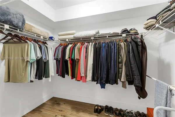 a view of walk in closet with clothes and shoes