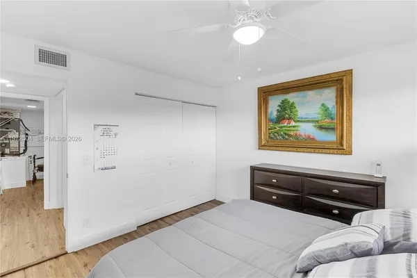 a bedroom with a bed and a painting on the wall