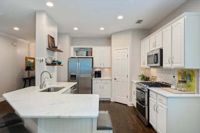 a kitchen with stainless steel appliances granite countertop a sink stove and refrigerator
