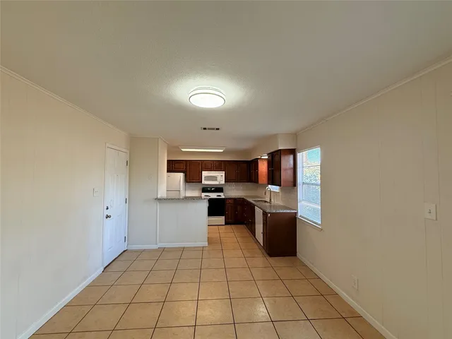 a kitchen with granite countertop a refrigerator and a stove