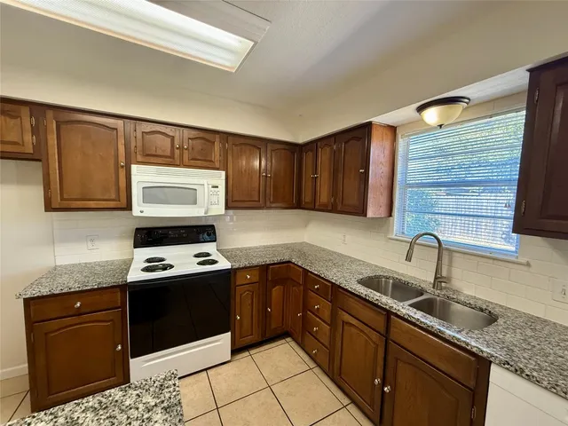 a kitchen with stainless steel appliances granite countertop a sink stove and cabinets