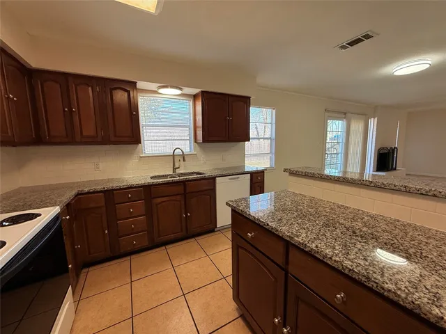 a kitchen with granite countertop wooden cabinets and a sink