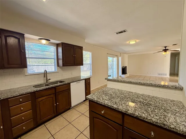 a kitchen with granite countertop wooden cabinets and a sink