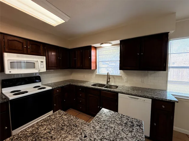 a kitchen with granite countertop a stove and a sink
