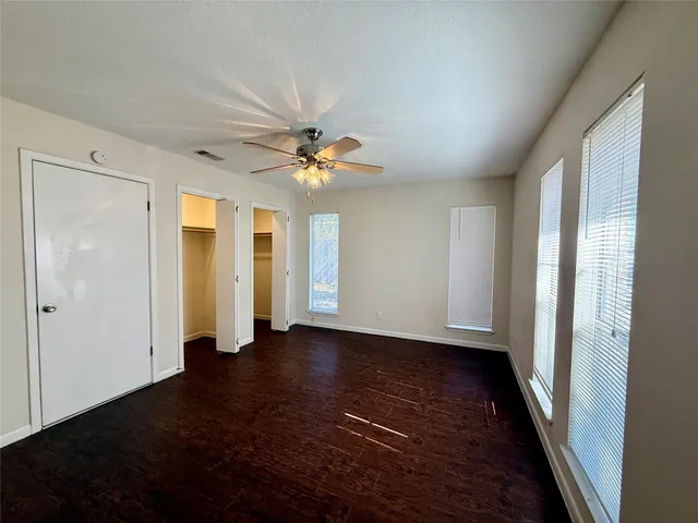 a view of empty room with wooden floor