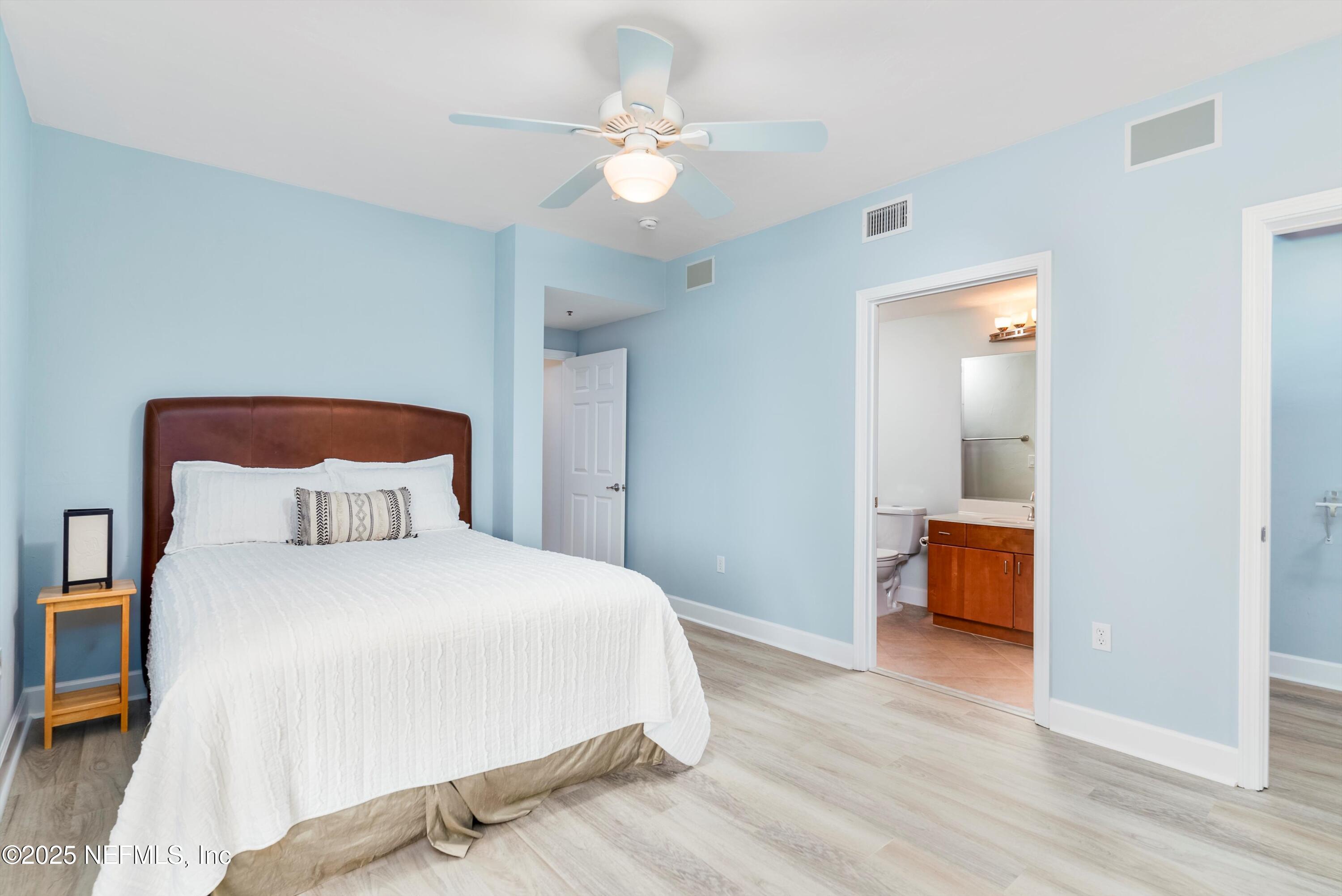 7790 A1A South, Unit 104 St. Augustine, FL 32080 - Photo 14 of 51 a bedroom with a bed and a chandelier