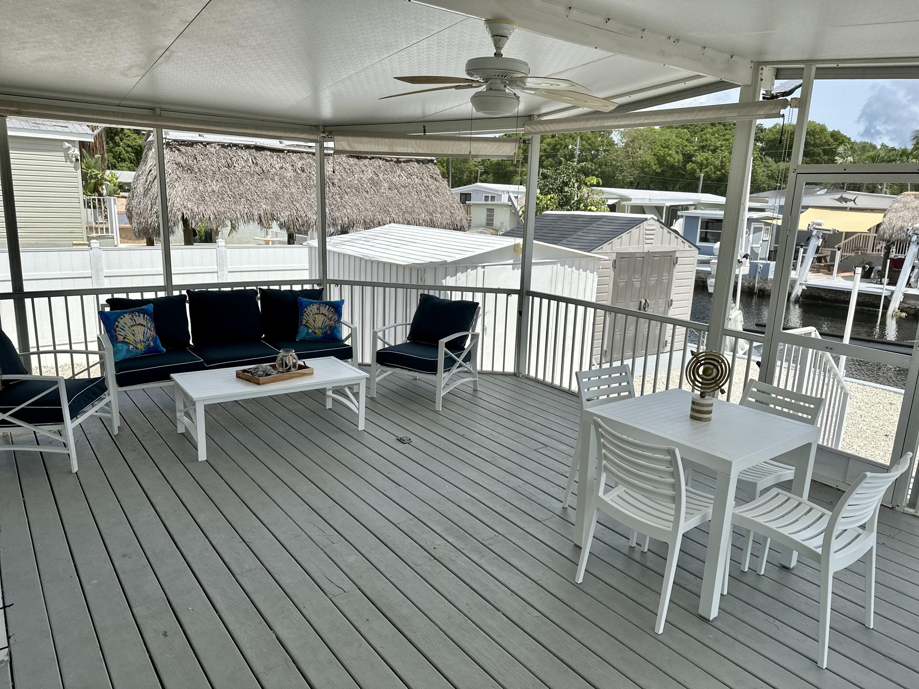 240 Taylor Drive Key Largo, FL 33037 - Photo 18 of 25 a view of a patio with dining table and chairs with wooden floor
