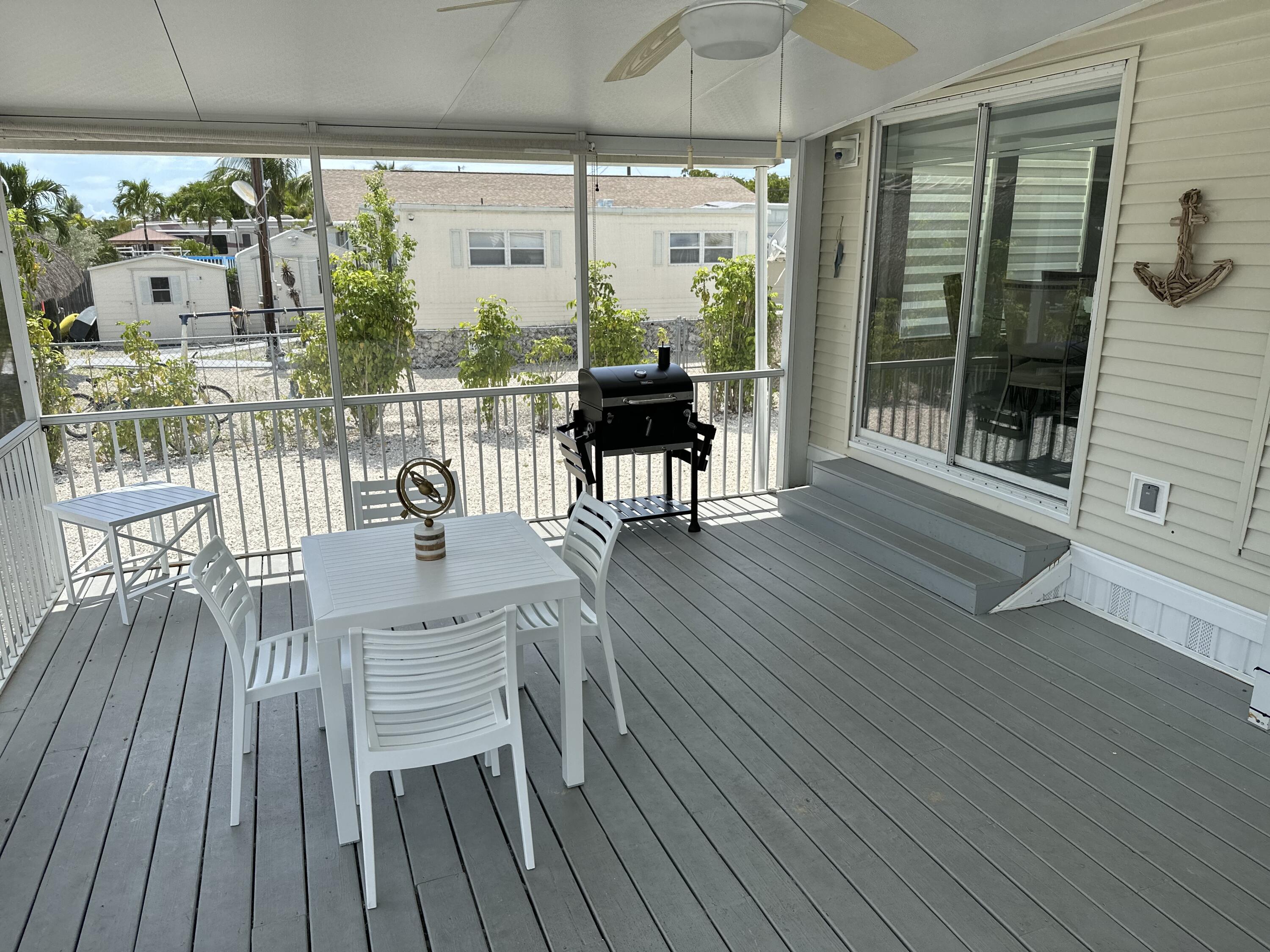 240 Taylor Drive Key Largo, FL 33037 - Photo 20 of 25 a dining room with wooden floor glass table and chairs