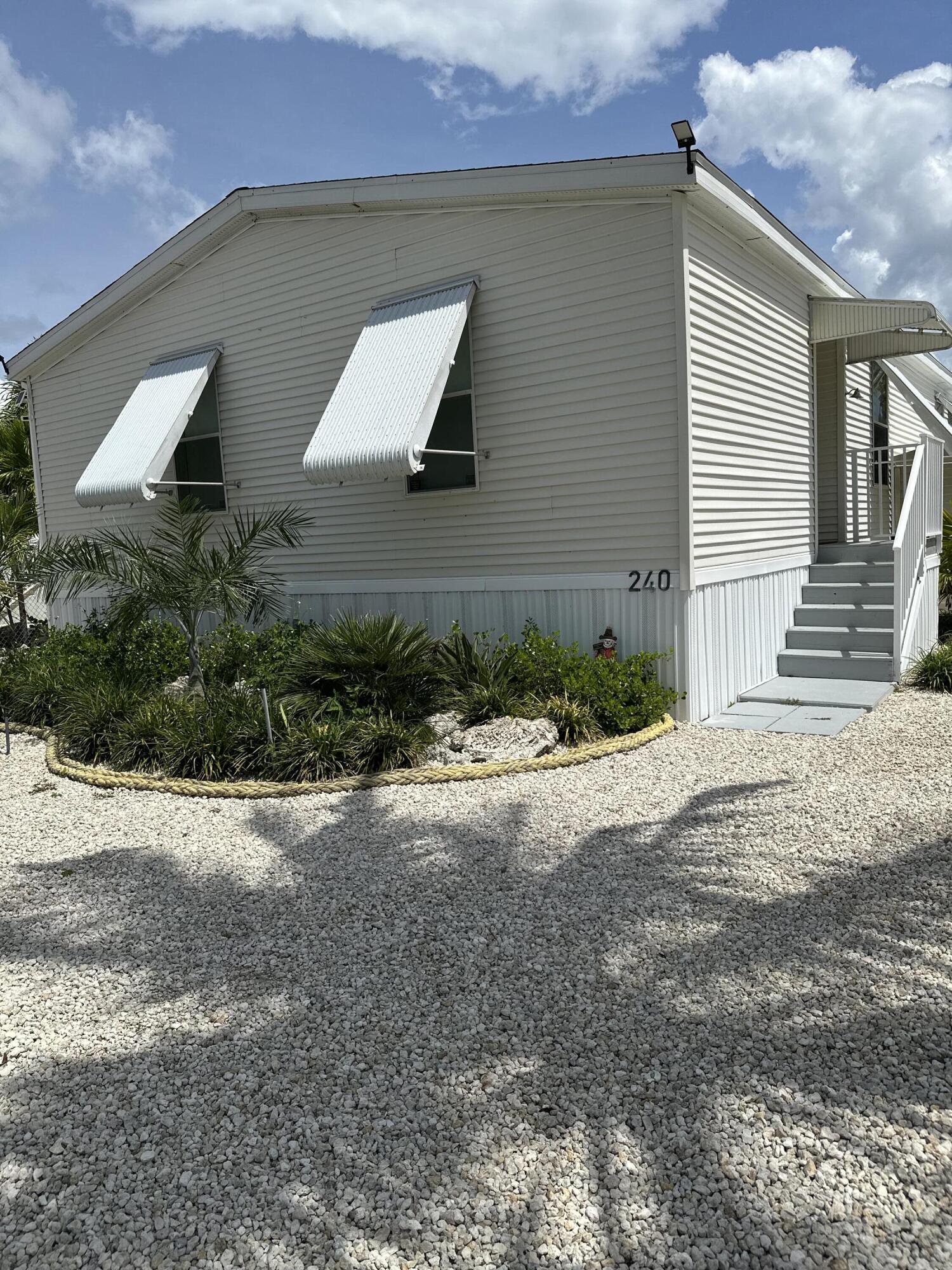 240 Taylor Drive Key Largo, FL 33037 - Photo 2 of 25 a front view of a house with a yard