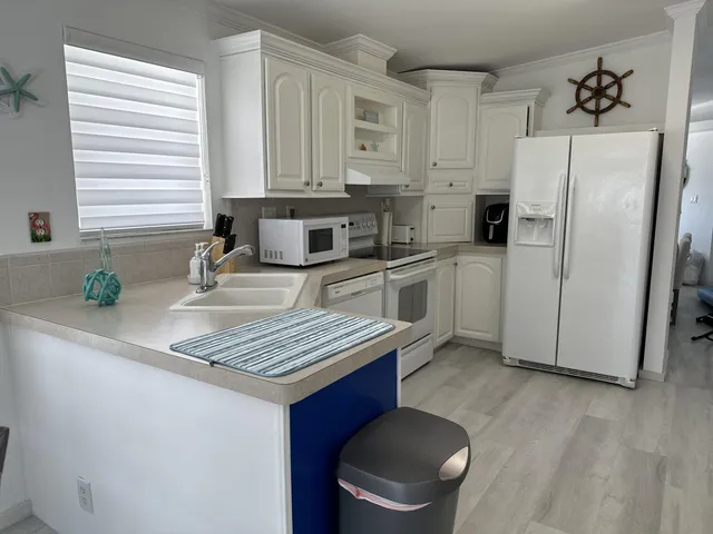 a kitchen with stainless steel appliances granite countertop a sink a refrigerator and a stove