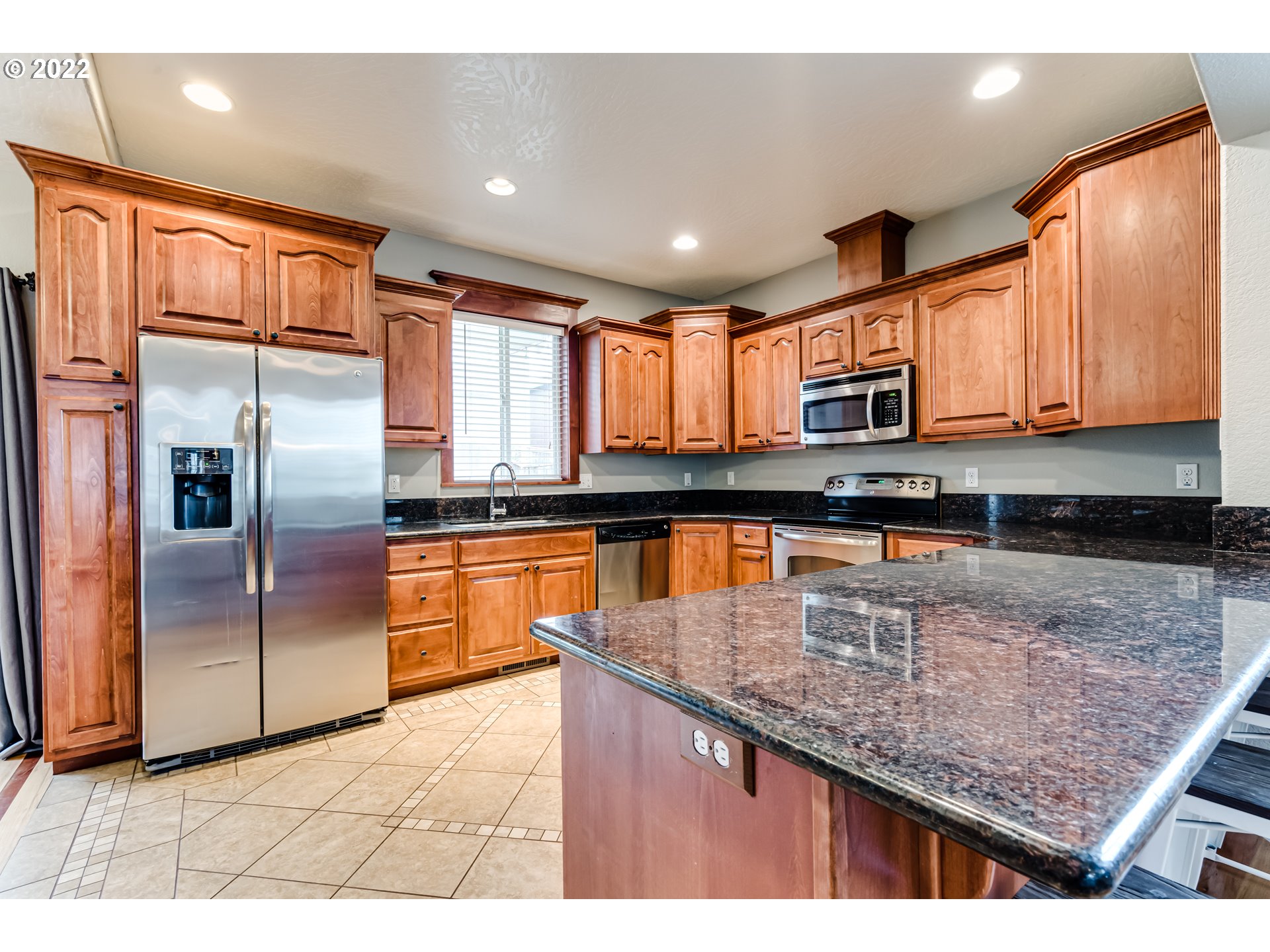 5722 Peridot Way Springfield, OR 97478 - Photo 7 of 27 a kitchen with stainless steel appliances granite countertop a refrigerator a stove and a sink with wooden floors