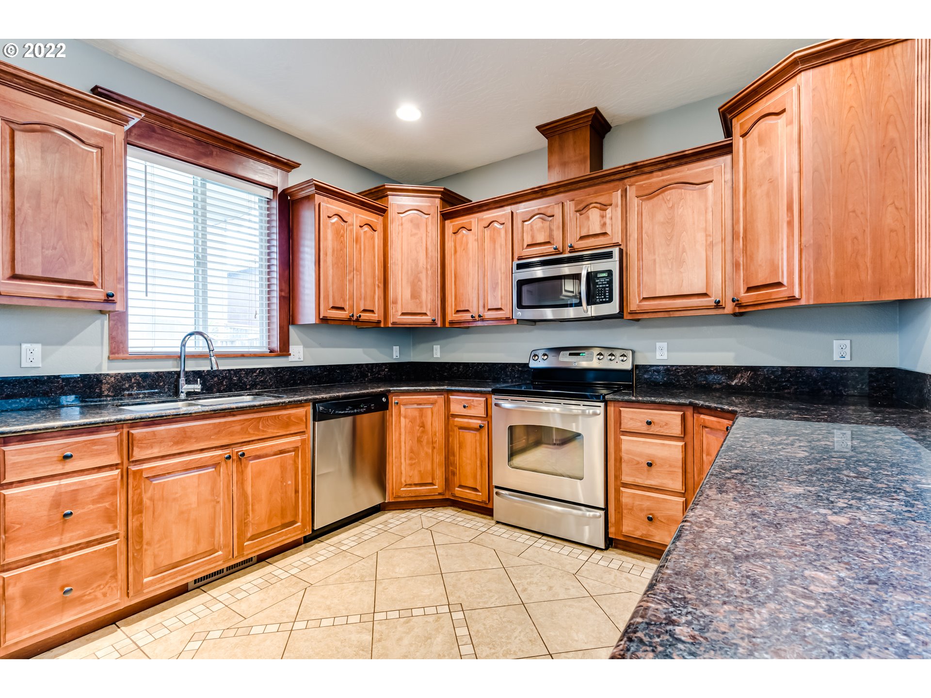 5722 Peridot Way Springfield, OR 97478 - Photo 8 of 27 a kitchen with granite countertop a stove a sink and a microwave