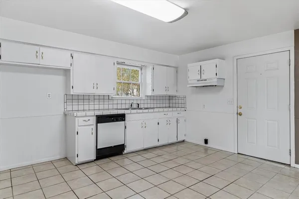 a kitchen with white cabinets appliances and a sink