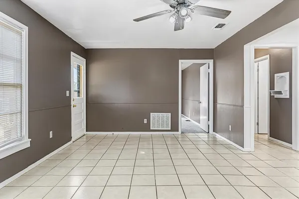 a view of a livingroom with a chandelier fan and windows
