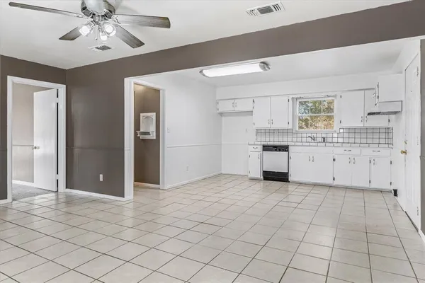 a view of kitchen with granite countertop cabinets and window