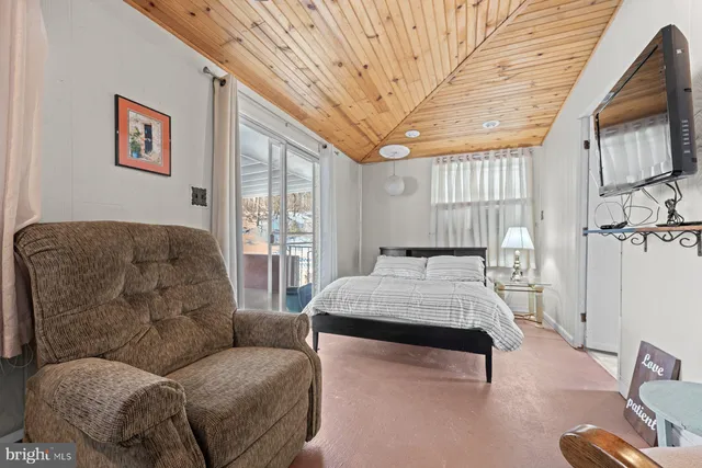 a living room with furniture a flat screen tv and windows