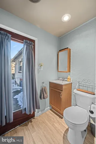a bathroom with a granite countertop toilet sink and mirror